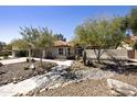 Charming single-story home featuring xeriscaping, mature trees, and a stone walkway to the front entry at 9230 N 104Th Pl, Scottsdale, AZ 85258