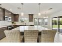 Kitchen island with quartz countertops, wicker barstools, pendant lights, and backyard view at 9230 N 104Th Pl, Scottsdale, AZ 85258