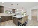 Modern kitchen featuring quartz countertops, custom cabinets, stainless steel appliances, and breakfast bar seating at 9230 N 104Th Pl, Scottsdale, AZ 85258