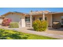 Tan house with pergola and blooming pink flowers at 10429 W Highwood Ln, Sun City, AZ 85373