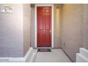 Inviting entryway with a red front door and a welcoming mat at 18176 W Paradise Ln, Surprise, AZ 85388