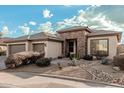 Single-story home with a two-car garage and stone accents at 18193 W Buckhorn Dr, Goodyear, AZ 85338