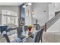 Bright dining room with a modern glass table, complemented by a staircase and stylish decor at 1923 E Drake Dr, Tempe, AZ 85283