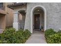 Arched entryway with a dark brown door and lush greenery at 3910 E Turley St, Gilbert, AZ 85295