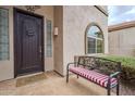 Inviting front entry with dark wooden door and welcoming bench at 4264 S Columbine Way, Gold Canyon, AZ 85118
