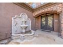 Elegant entryway with a beautiful fountain and ornate double doors at 4543 S Roy Rogers Way, Gilbert, AZ 85297