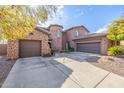 Two-story home with stone accents and a three-car garage at 4543 S Roy Rogers Way, Gilbert, AZ 85297