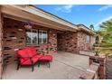 Cozy front porch with seating, potted plants, and a brick facade at 7950 E Lakeview Ave, Mesa, AZ 85209