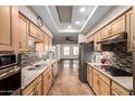 Well-appointed kitchen with stainless steel appliances, tiled backsplash, and natural wood cabinetry at 7950 E Lakeview Ave, Mesa, AZ 85209