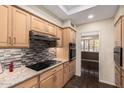 Kitchen featuring stone countertops, mosaic backsplash, light wood cabinetry, and stainless appliances at 7950 E Lakeview Ave, Mesa, AZ 85209