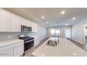 Modern kitchen with white cabinets, stainless steel appliances, and quartz countertops at 9699 S Mara Dr, Apache Junction, AZ 85120