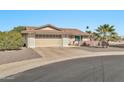 House exterior showcasing a tan brick facade, a two car garage and desert landscaping at 10312 W Sierra Dawn Dr, Sun City, AZ 85351