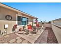 Small patio with red chairs and table, next to a rock wall and a flag at 10312 W Sierra Dawn Dr, Sun City, AZ 85351