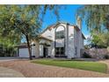 Two-story house with a white exterior, attached garage, and grassy front yard at 1126 E San Remo Ave, Gilbert, AZ 85234