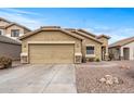 Tan house with a two-car garage and desert landscaping at 11608 W Oglesby Ave, Youngtown, AZ 85363