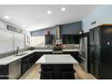 Modern kitchen with dark cabinetry, marble countertops, stainless steel appliances, and a kitchen island with seating at 16241 S 40Th Way, Phoenix, AZ 85048