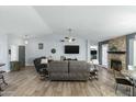 Spacious living room featuring wood floors, vaulted ceilings, a ceiling fan, and a stone fireplace at 16241 S 40Th Way, Phoenix, AZ 85048