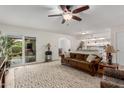 Living room with brown couch, ceiling fan, and view to backyard at 16420 N Scorpion Dr, Fountain Hills, AZ 85268