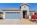 Single-story home with a two-car garage and well-maintained landscaping at 17962 W Vogel Ave, Waddell, AZ 85355