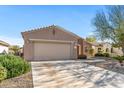 Front view of a tan house with a two-car garage and desert landscaping at 20533 N Sequoia Crest Dr, Surprise, AZ 85387