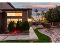 Landscaped backyard with walkway, rock garden, and string lights at 21054 N 74Th Ln, Glendale, AZ 85308