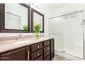 Bathroom with double sinks, dark wood cabinets, and a shower at 21362 E Puesta Del Sol Rd, Queen Creek, AZ 85142
