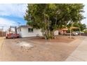 Ranch style home with mature tree and gravel driveway at 2206 W Glendale Ave, Phoenix, AZ 85021