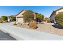 Tan house with a two-car garage and desert landscaping at 22402 W Harrison St, Buckeye, AZ 85326