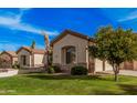 Charming home featuring lush green lawns and mature trees enhancing its curb appeal at 2939 E Huber St, Mesa, AZ 85213