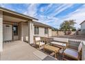 Covered front porch with a cozy seating area and well-maintained desert landscaping at 4542 W Villa Theresa Dr, Glendale, AZ 85308