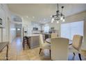 Bright kitchen with island, dining area, and white shaker cabinets at 5153 W Pontiac Dr, Glendale, AZ 85308