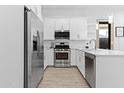 Modern kitchen with stainless steel appliances, white cabinetry, and tile backsplash at 5724 S Coyote Cyn, Mesa, AZ 85212