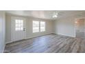 Living room with wood-look floors and door to outside at 645 S Warren Rd, Maricopa, AZ 85139