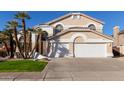 Tan two-story house with white garage doors and palm trees at 6970 W Morning Dove Dr, Glendale, AZ 85308