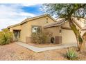 Tan house with a two-car garage and landscaping at 15348 W Banff Ln, Surprise, AZ 85379