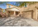Inviting two-story home with a large driveway, stylish front door, and covered porch with decorative stone pillars at 2036 E Stacey Rd, Gilbert, AZ 85298