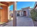 Private courtyard entry with brick flooring and a wood door at 42413 W Abbey Rd, Maricopa, AZ 85138