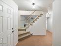 A carpeted staircase with a white railing in a light-toned foyer at 7447 E Christmas Cholla Dr, Scottsdale, AZ 85255
