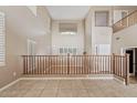 High-ceilinged living room with hardwood floors and a wooden railing at 7603 W Encinas Ln, Phoenix, AZ 85043