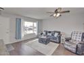 Living room with hardwood floors, large window, and comfortable seating area at 9710 W Rodeo Ct, Sun City, AZ 85373