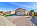 A single-story home boasts a well-maintained lawn, two-car garage, and brick-paved driveway at 1041 N 91St Pl, Mesa, AZ 85207