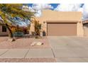 Tan house with brown garage door, desert landscaping, and a bench at 10454 E Peralta Canyon Dr, Gold Canyon, AZ 85118