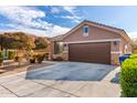 Single-story home with brown garage door and landscaping at 12021 W Locust Ln, Avondale, AZ 85323