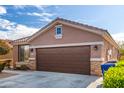 Single-story home with brown garage door and landscaping at 12021 W Locust Ln, Avondale, AZ 85323