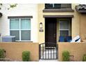 Inviting townhome entrance with dark wood door, black metal gate, and desert landscaping at 1255 N Arizona Ave # 1297, Chandler, AZ 85225