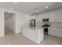 Modern kitchen with white cabinets, stainless steel appliances, and a central island at 18225 W Hess St, Goodyear, AZ 85338