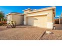 View of the home's front and garage, with a brick driveway at 18258 W Spencer Dr, Surprise, AZ 85374