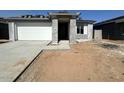 New construction home with concrete driveway, covered entryway and an attached two-car garage at 22844 E Lords Way, Queen Creek, AZ 85142