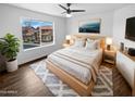 Bright bedroom with a large window, comfortable bed, and modern nightstands at 3835 E Kent Dr, Phoenix, AZ 85044