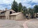 View of condo building featuring exterior garages and stairs leading to upper units at 6550 N 47Th Ave # 286, Glendale, AZ 85301